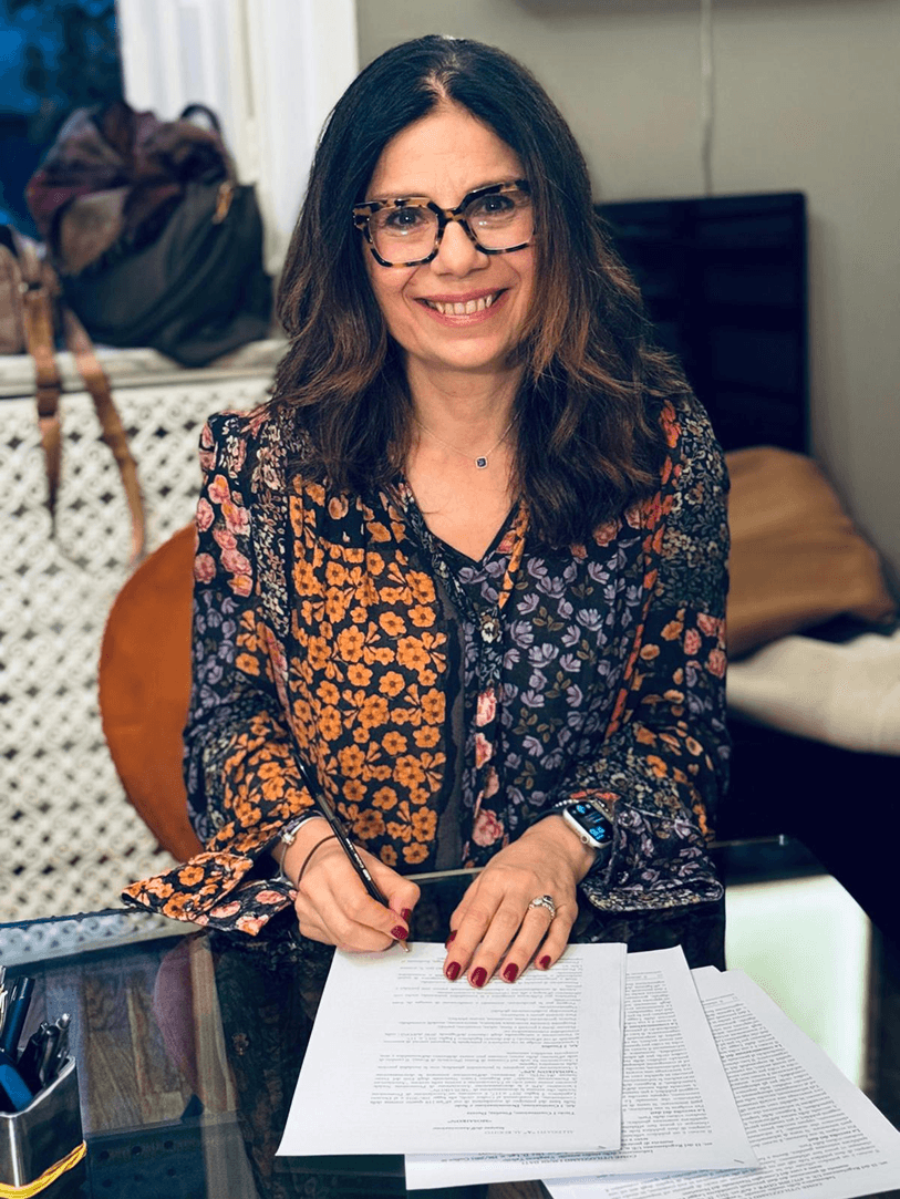 Paola Palmesano sorridente mentre firma un contratto